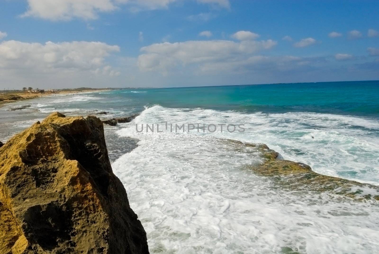 The rock towers over the sea washed by waves