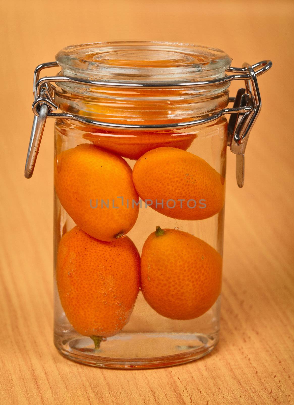 Kumquat is sealed in a small tin can on a wooden background