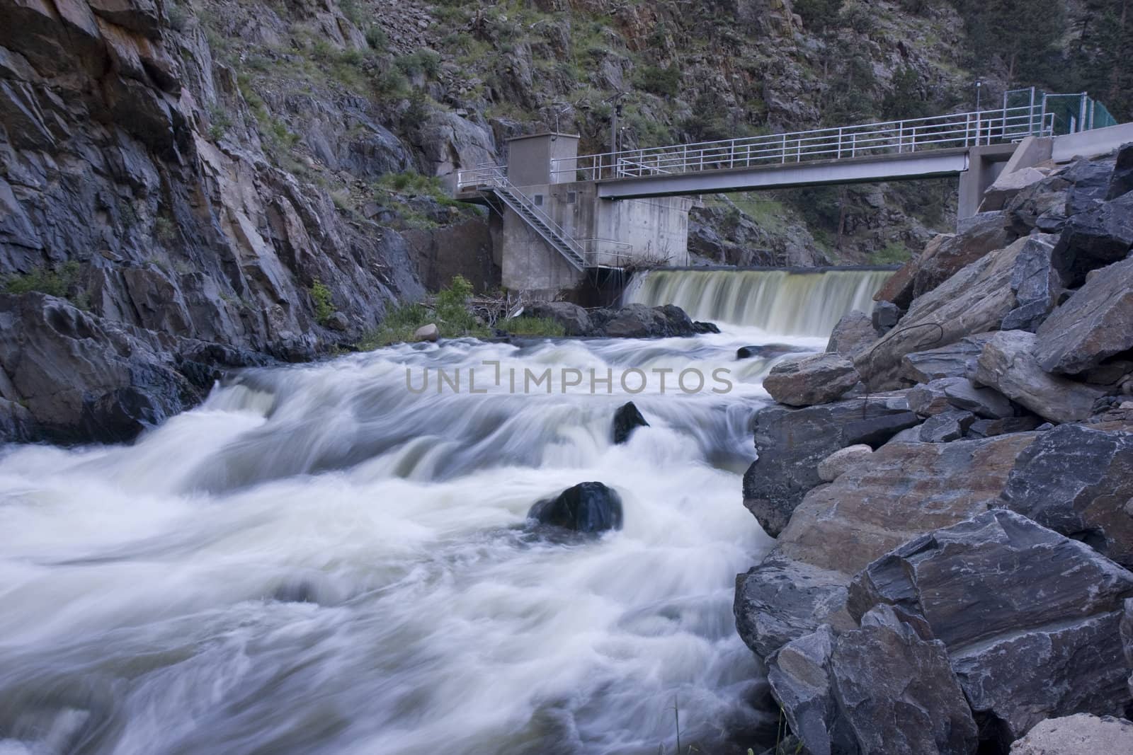 diversion dam on a mountain river flowing in deep, dark canyon by PixelsAway