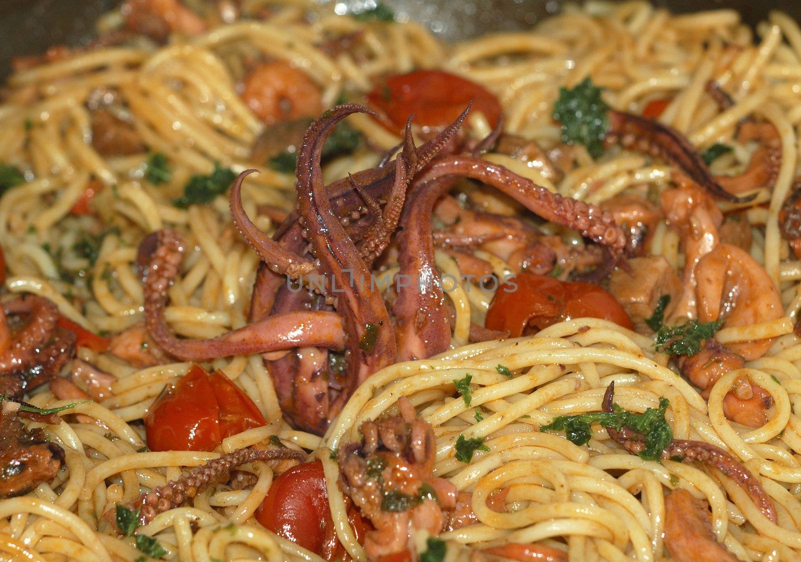 italian food, spaghetti pasta and a selection of seafood with tomato sauce and parsley