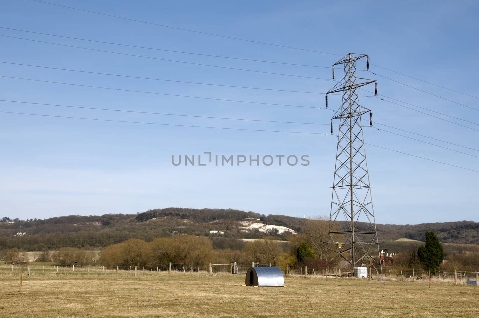 An electrical pylon in a field with a blue sky9