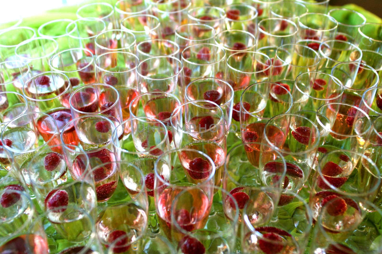 group of glasses with raspbberries and champagne