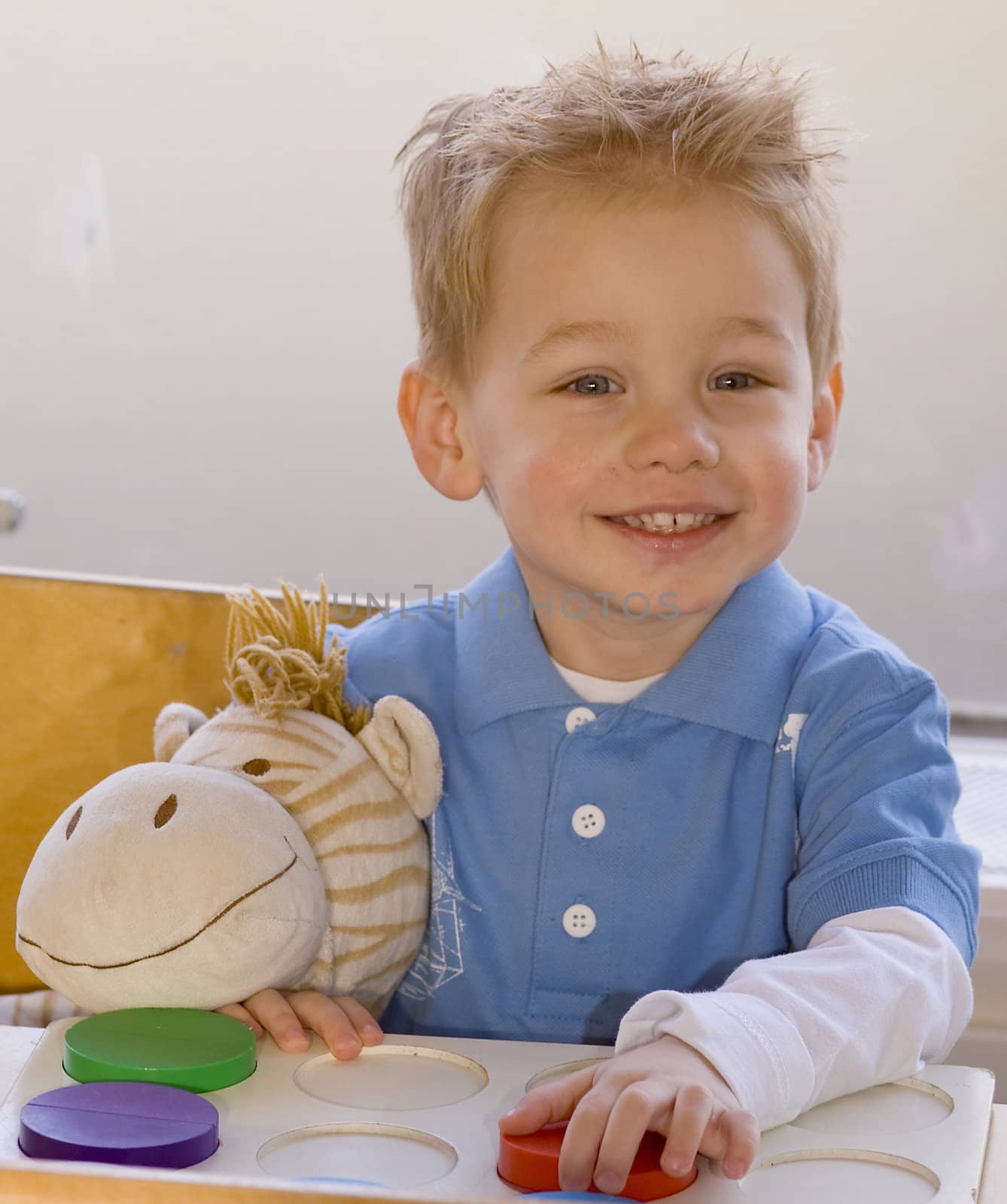 a toddler making a puzzle in nursery school