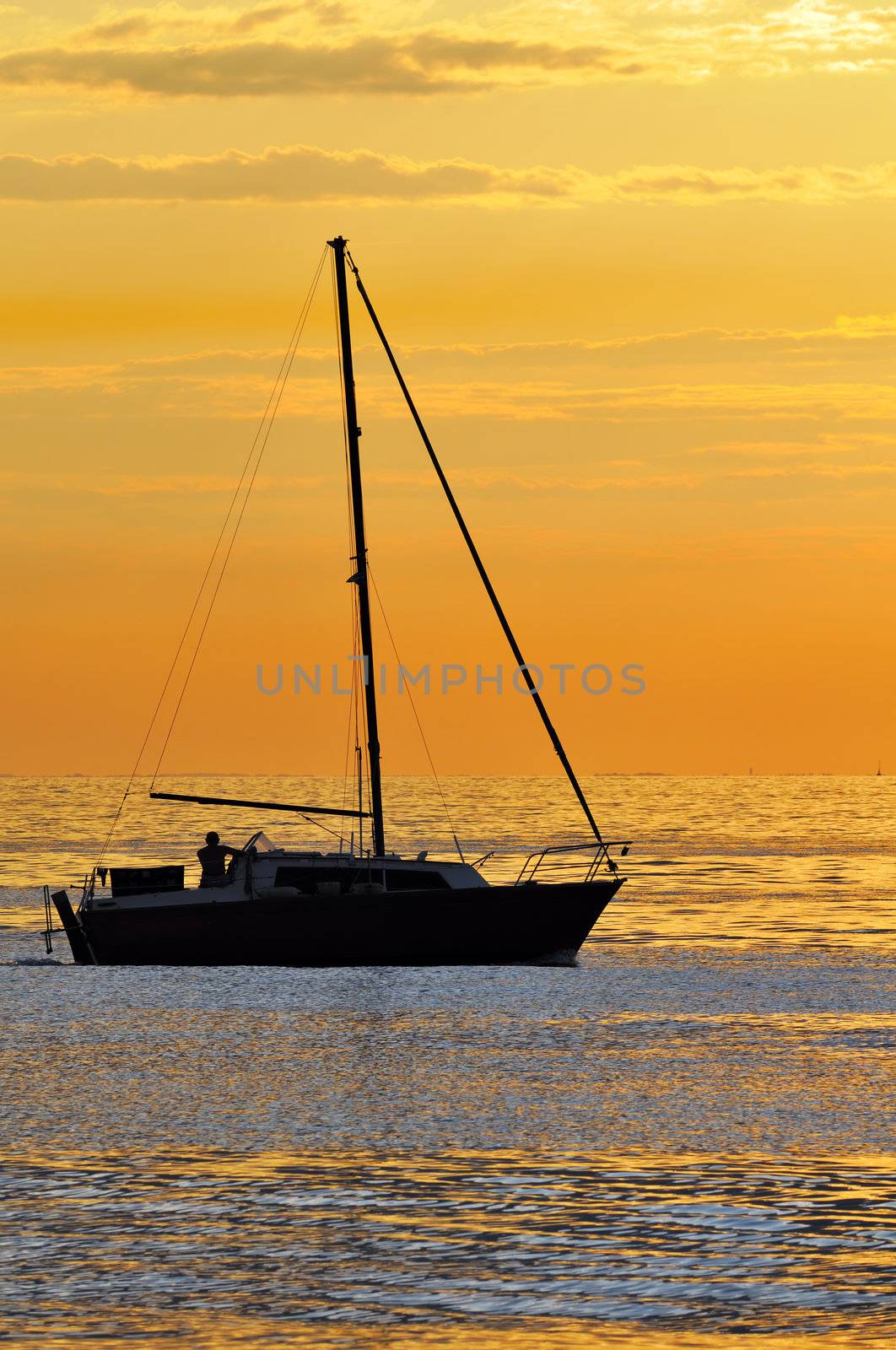 Silhouette of a boat navigating on the sea at the sunset