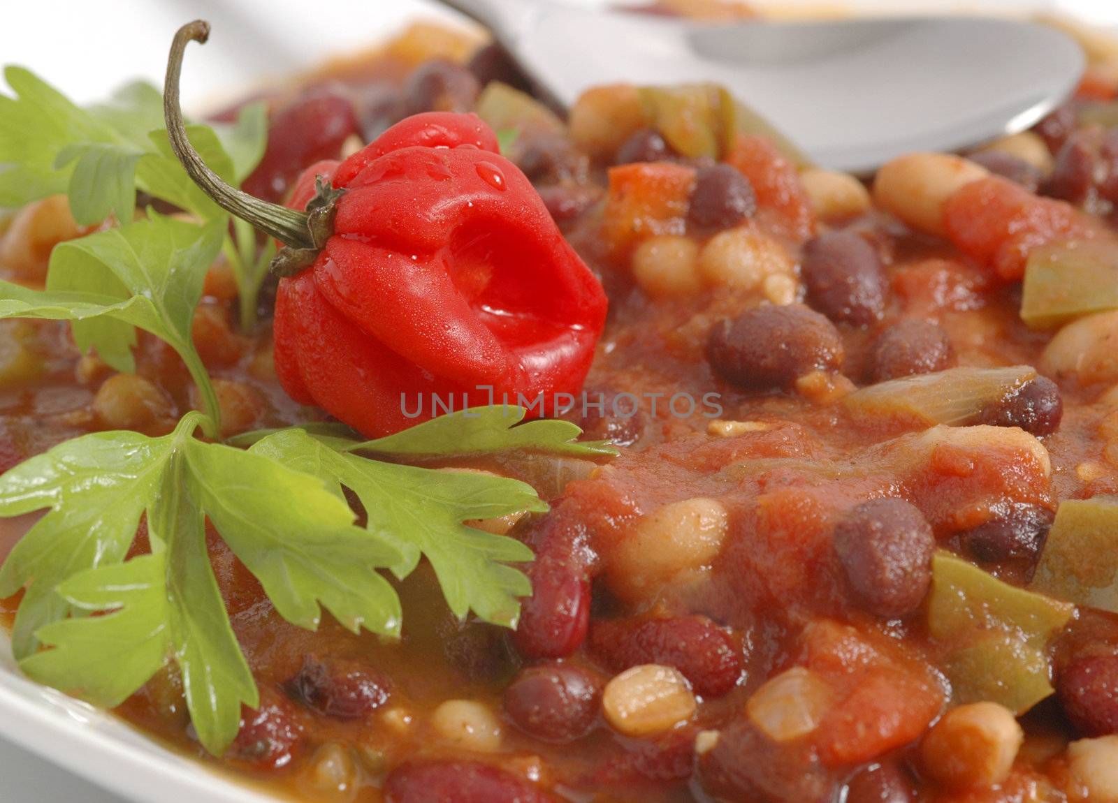 Bowl of vegetarian chili with pepper and cilantro garnish.