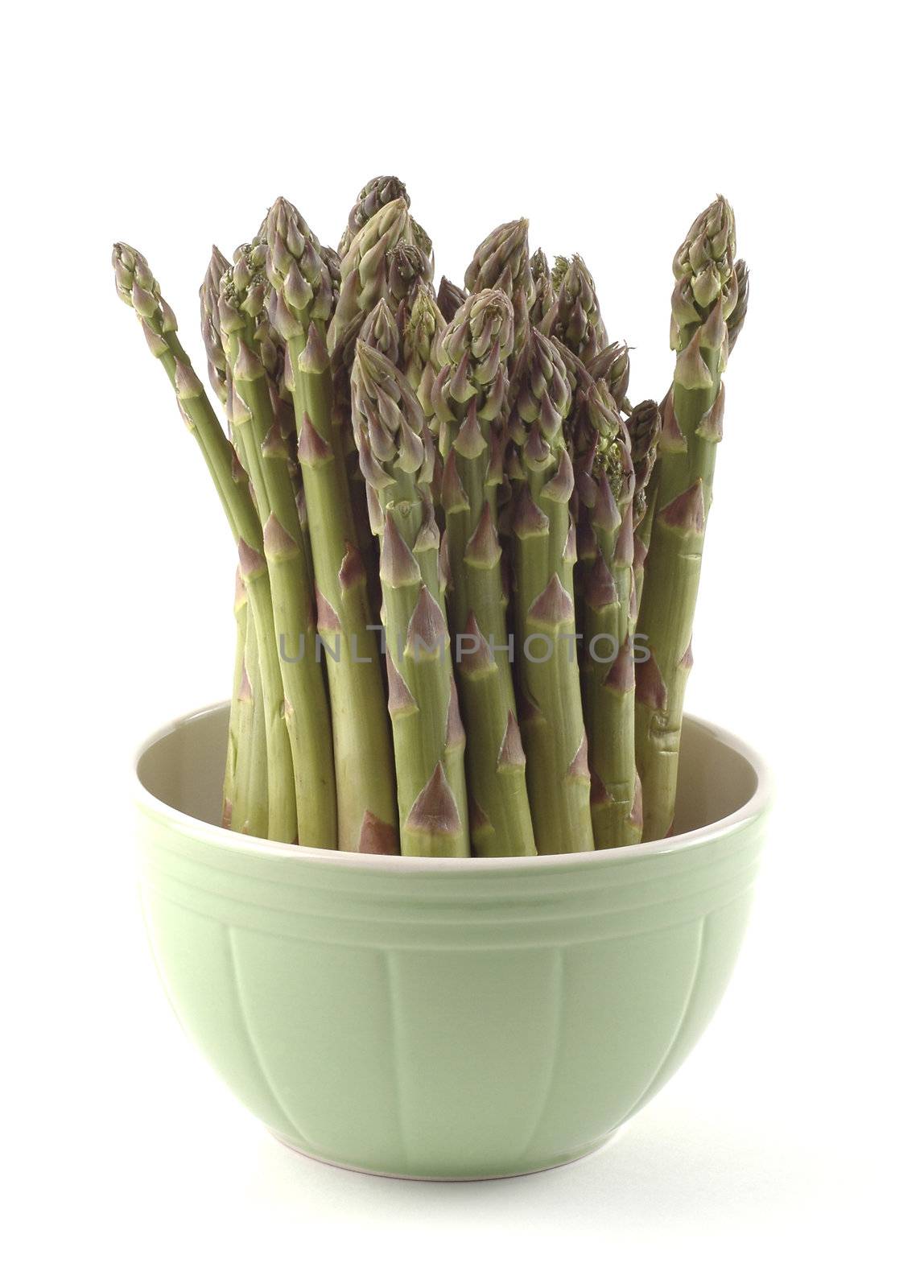 Fresh asparagus presented in a green bowl on white.
