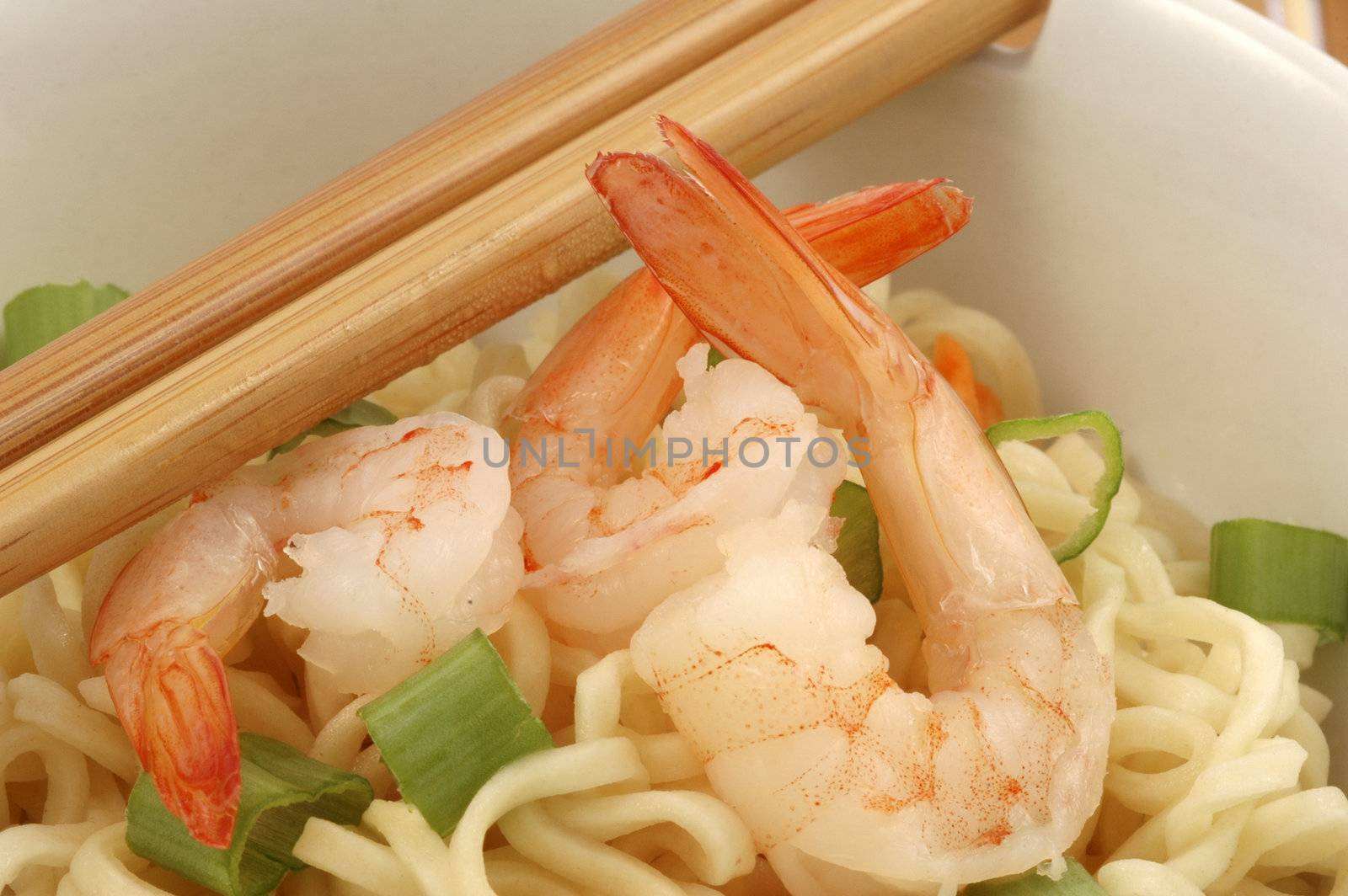 Bowl of oriental shrimp served with rice noodles.