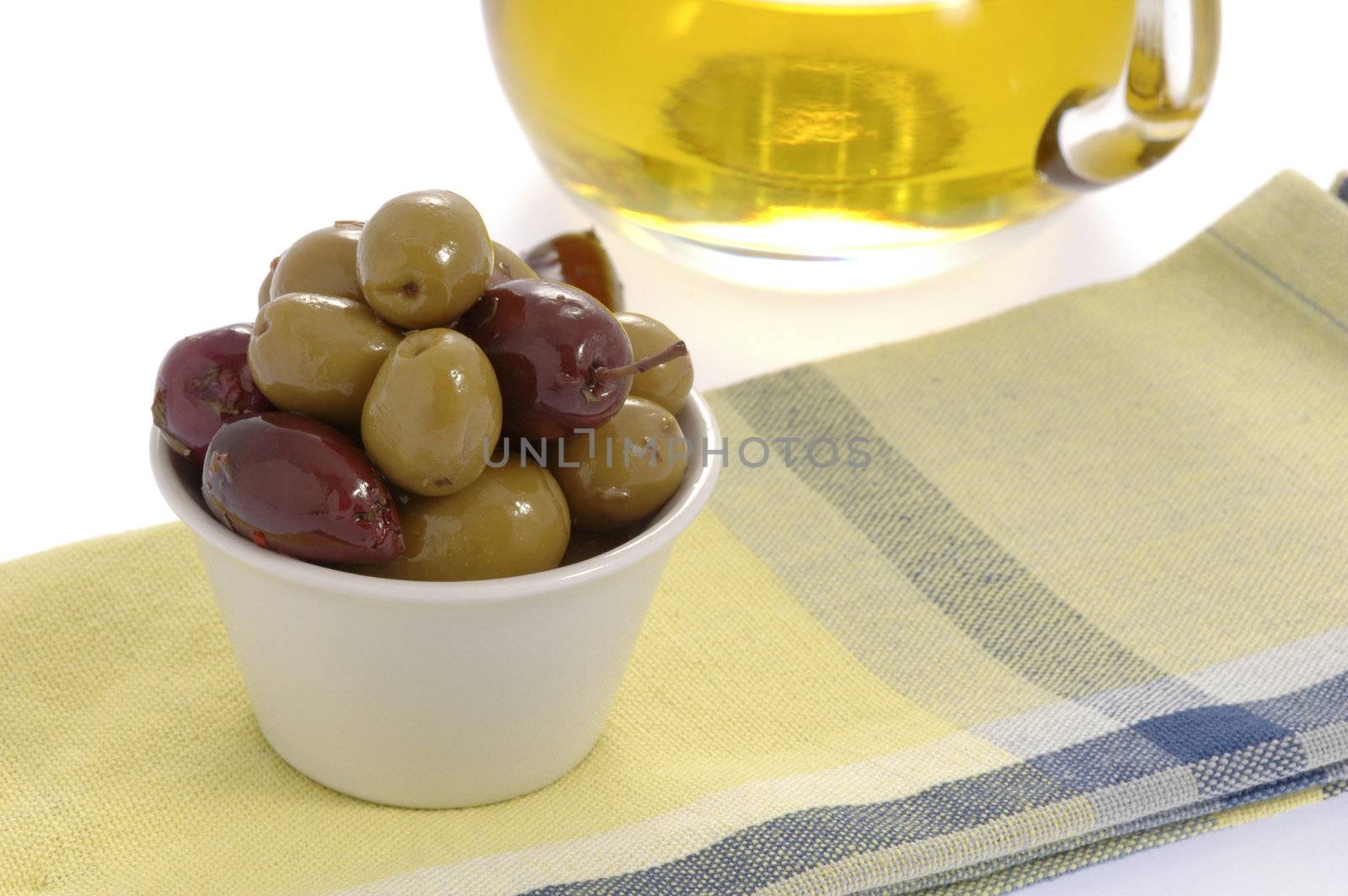Container of black and green olives and olive oil.