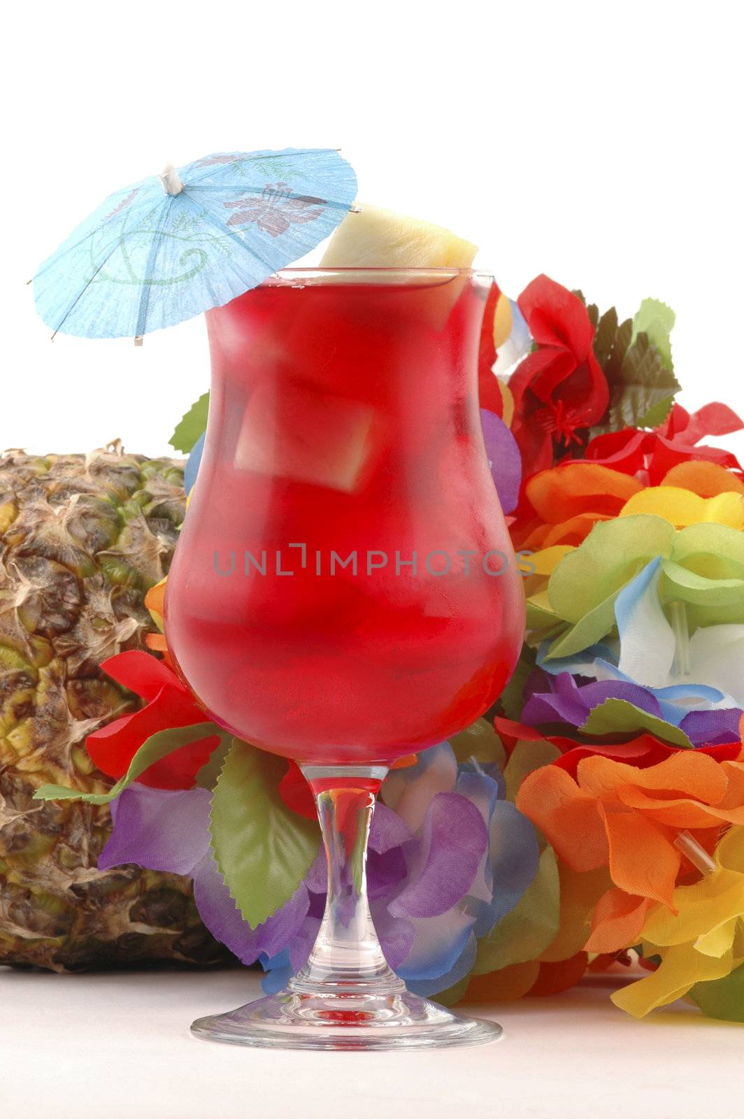 Red Tropical drink with colorful lei and pineapple.