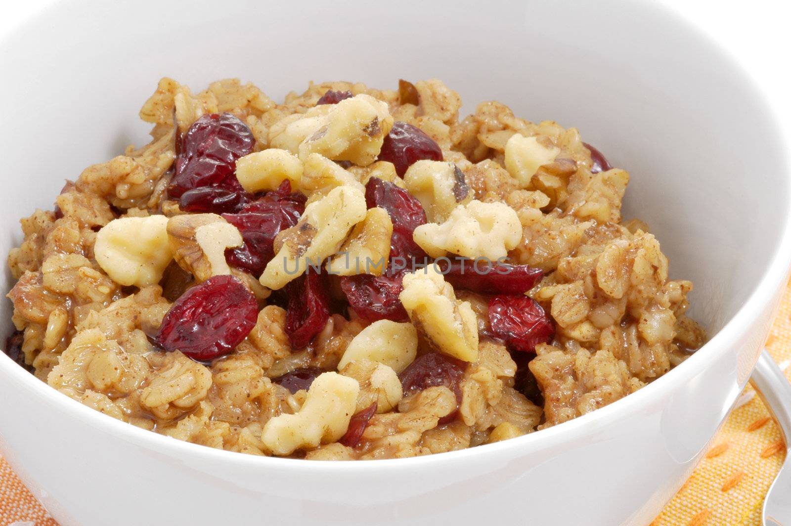 Bowl of oatmeal with dried fruit and nuts.