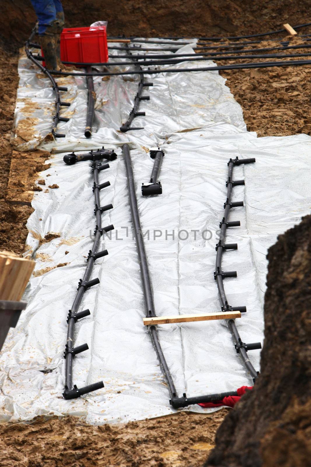 A geothermal heating system is built. The heating pipes are laid into the ground.