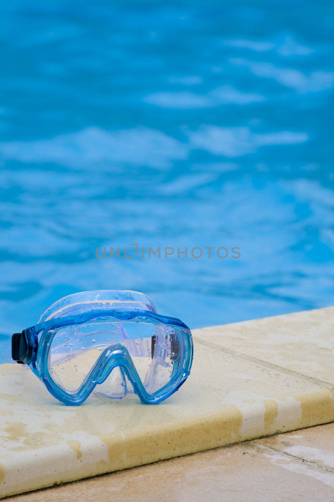 Diving mask on the bank of a swimming pool.