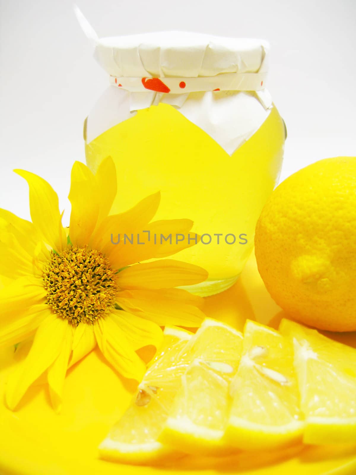 Jar of honey with lemon and yellow flower