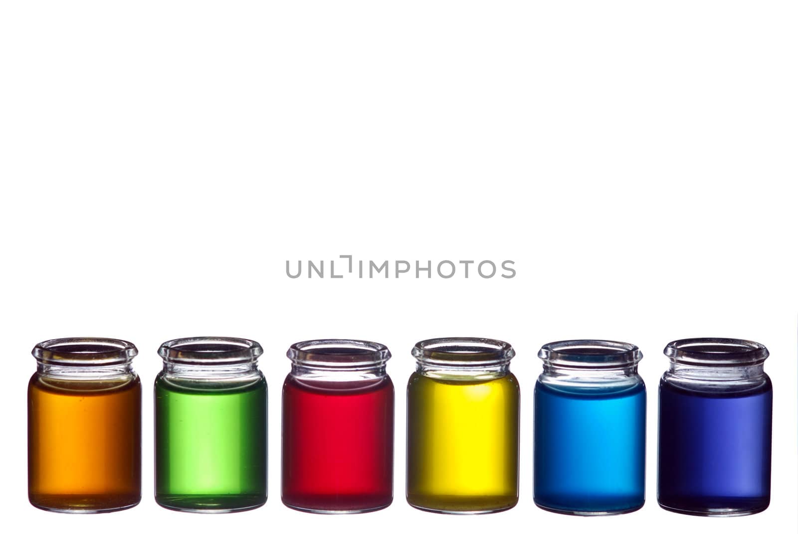 Line of glasses filled with colorful liquid isolated on white