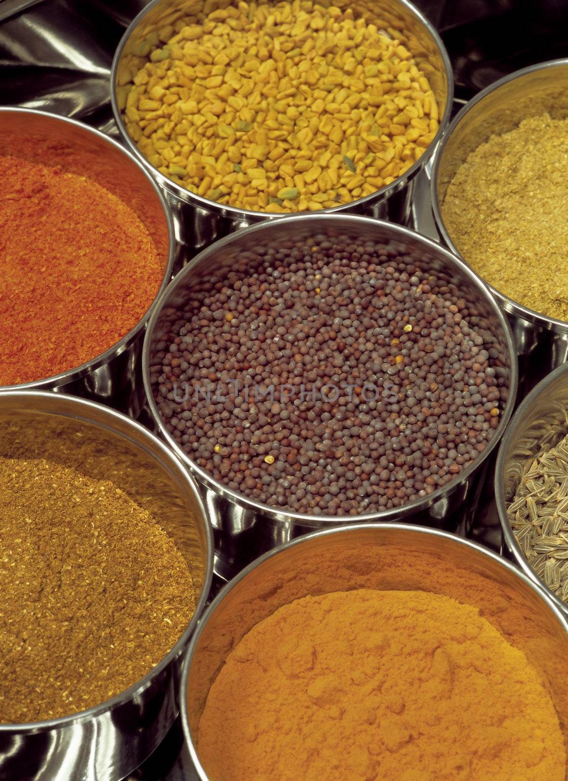 Indian spices - Masala box containing fenugreek, curry, garam, black mustard seeds, chilli, cumin seeds.
