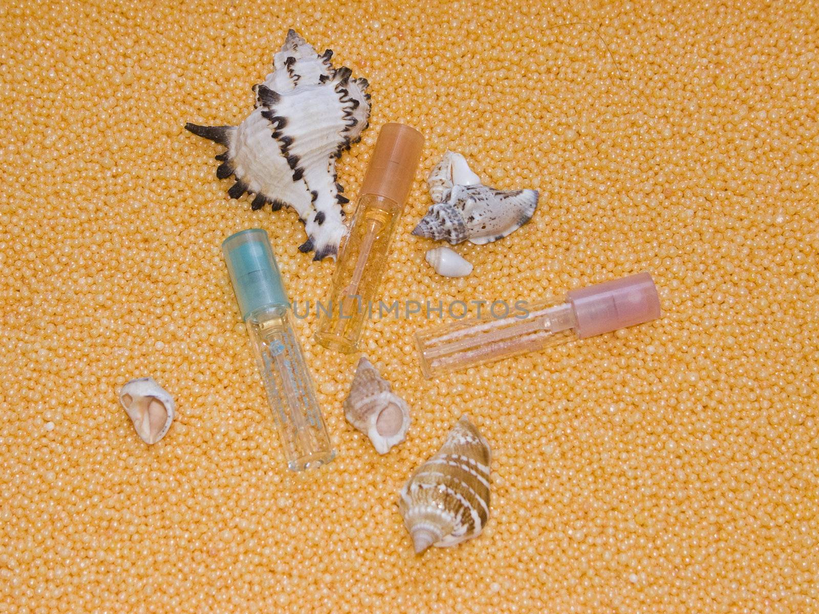 The image of bottles of perfume and cockleshells on a yellow background