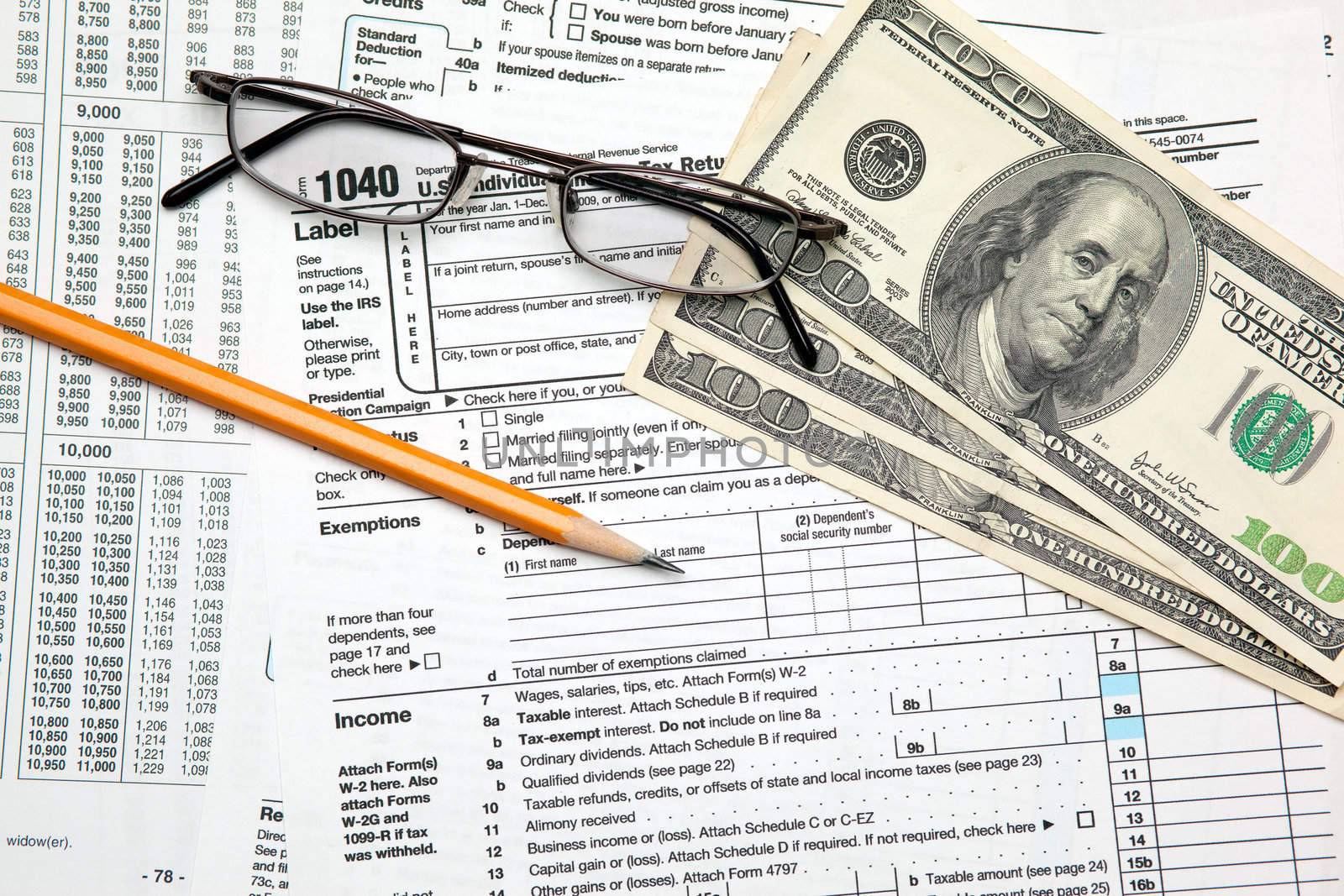 Tax time - Closeup of U.S. 1040 tax return with pencil and glass by svanblar