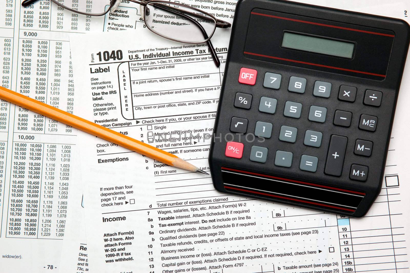 Tax time - Closeup of U.S. 1040 tax return with pencil, glasses  by svanblar