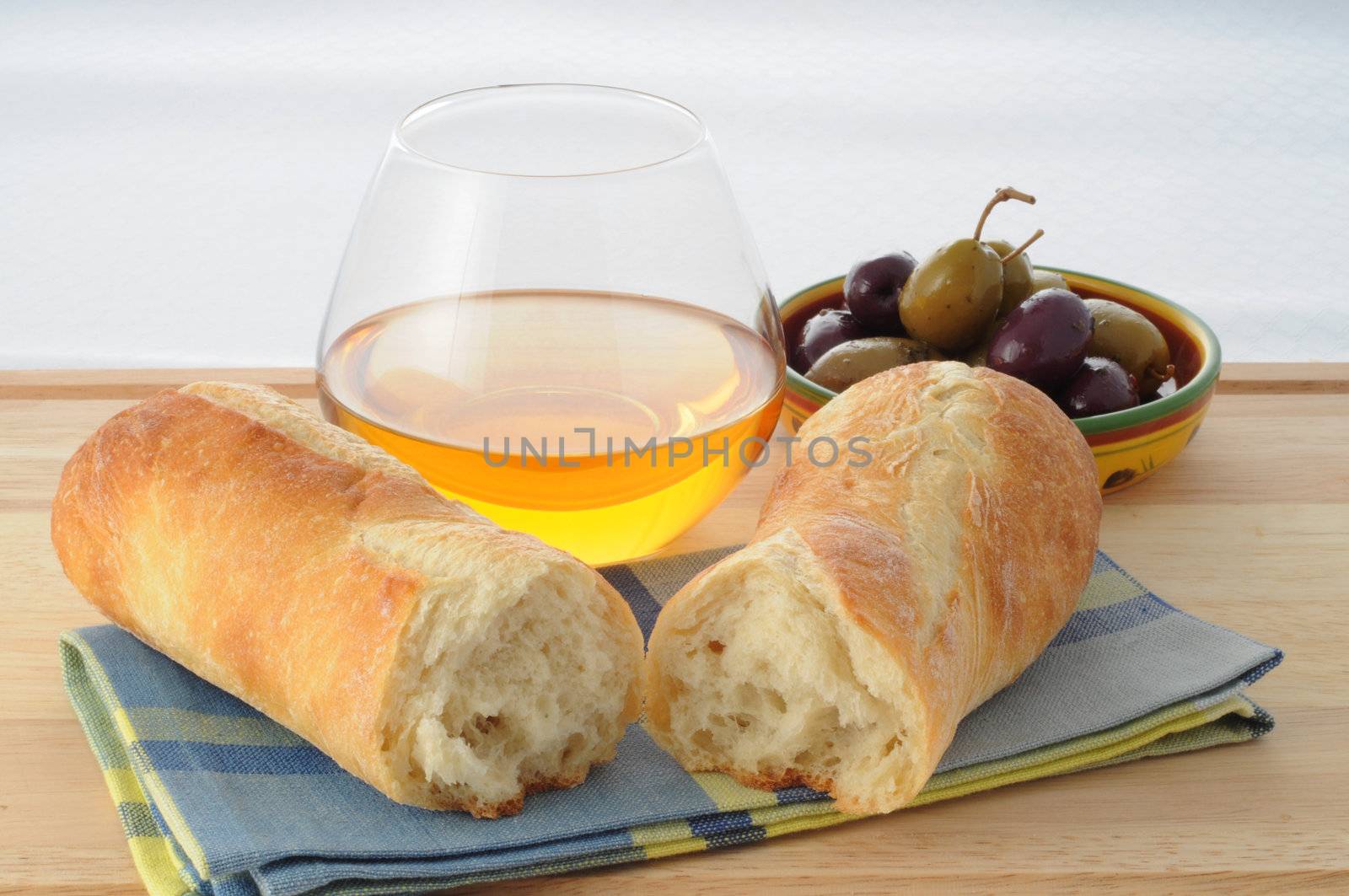 Freshly baked bread with olives and wine.