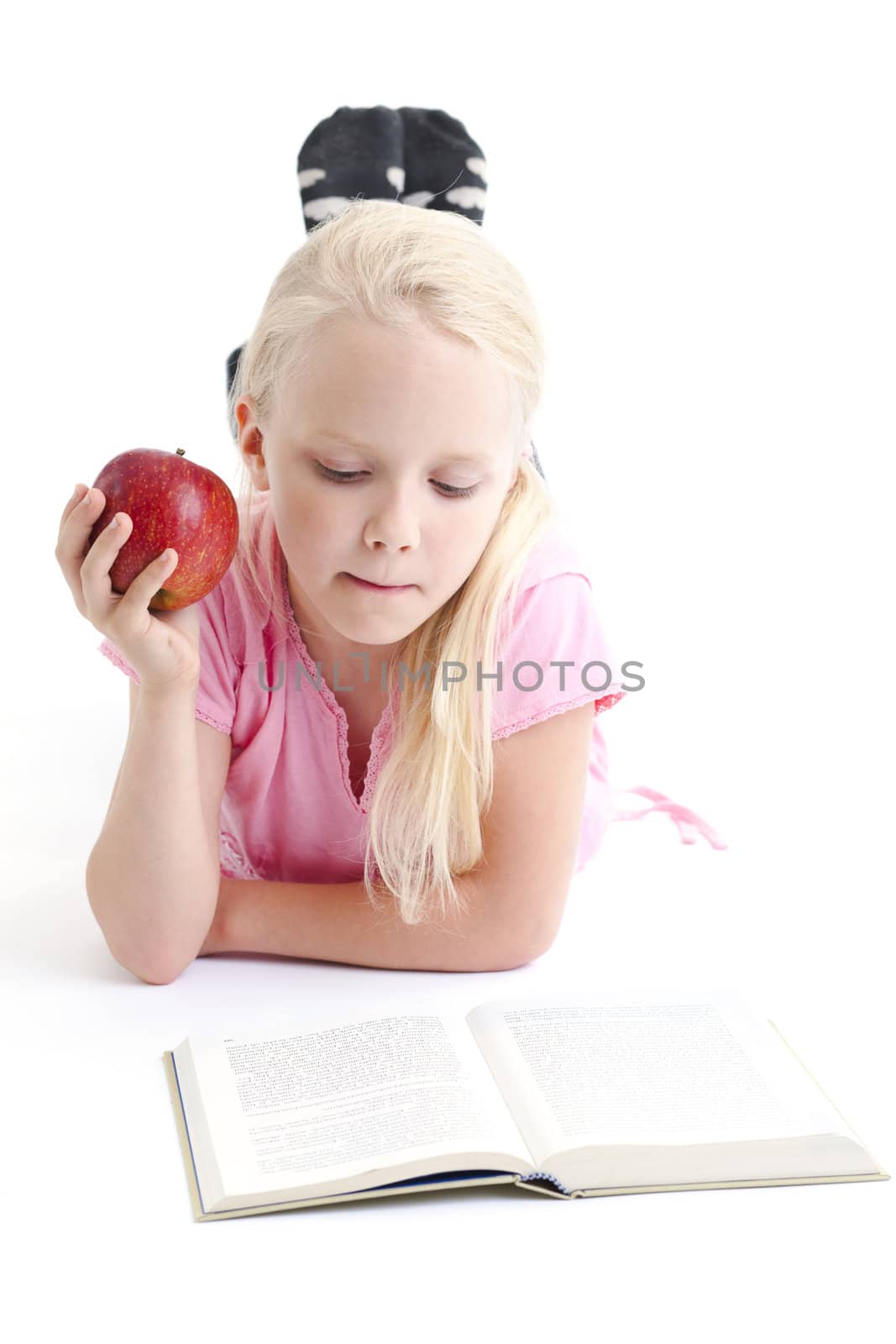 Young girl reading a book on the floor