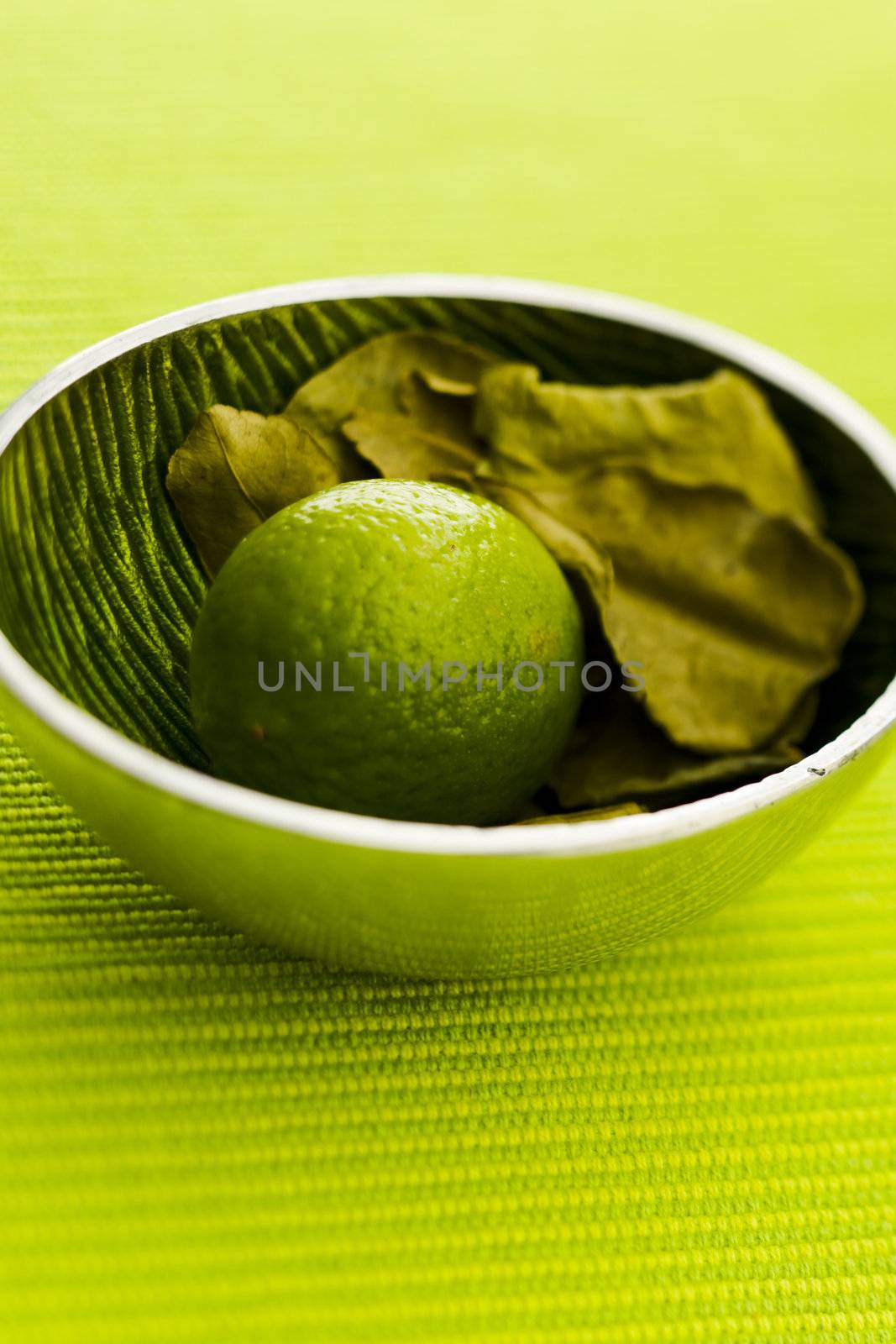 Lime with kafir leaves on the green table