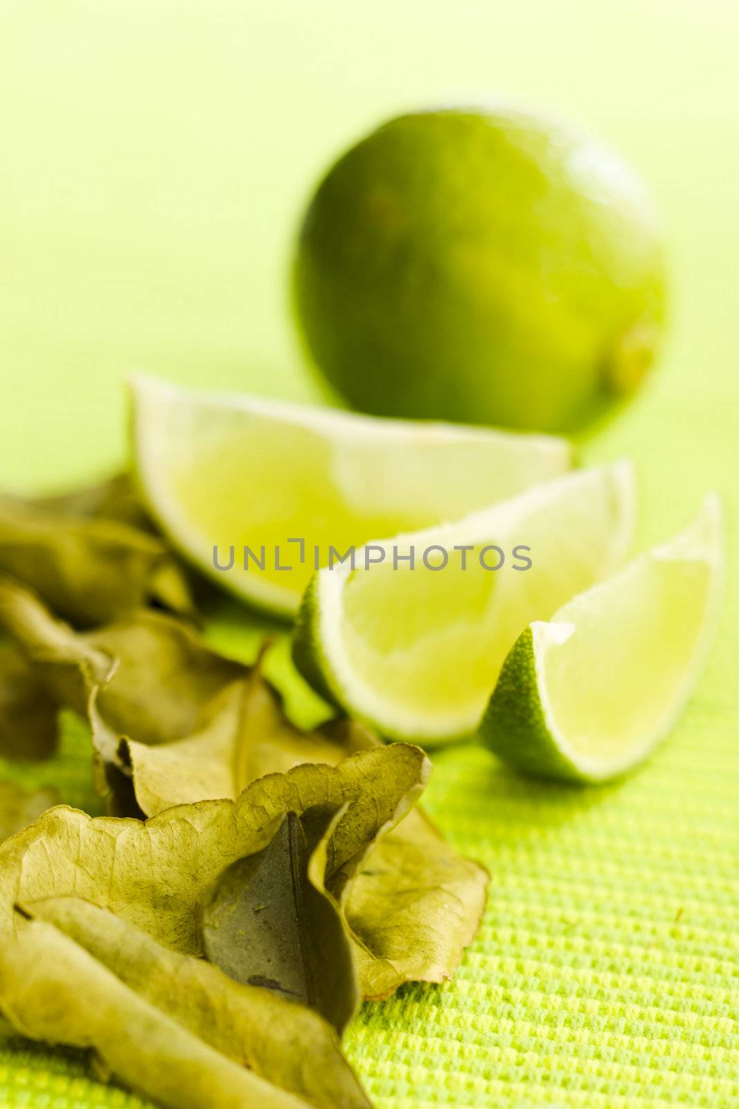 Lime with kafir leaves on the green table (shallow dof)