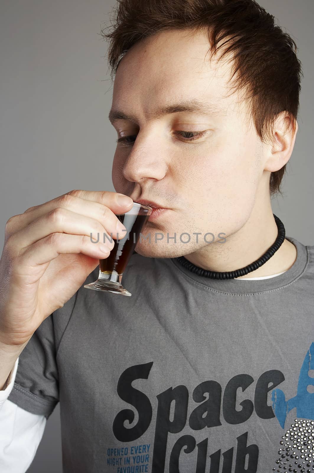 Man drinking a small shot of hard liquer