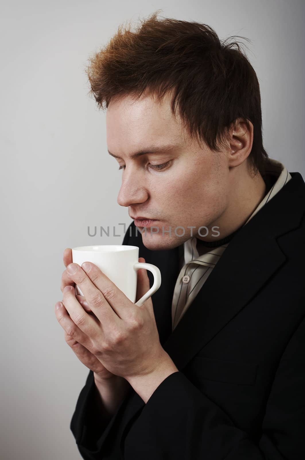 Businessman warming up with coffee cup after a cold day