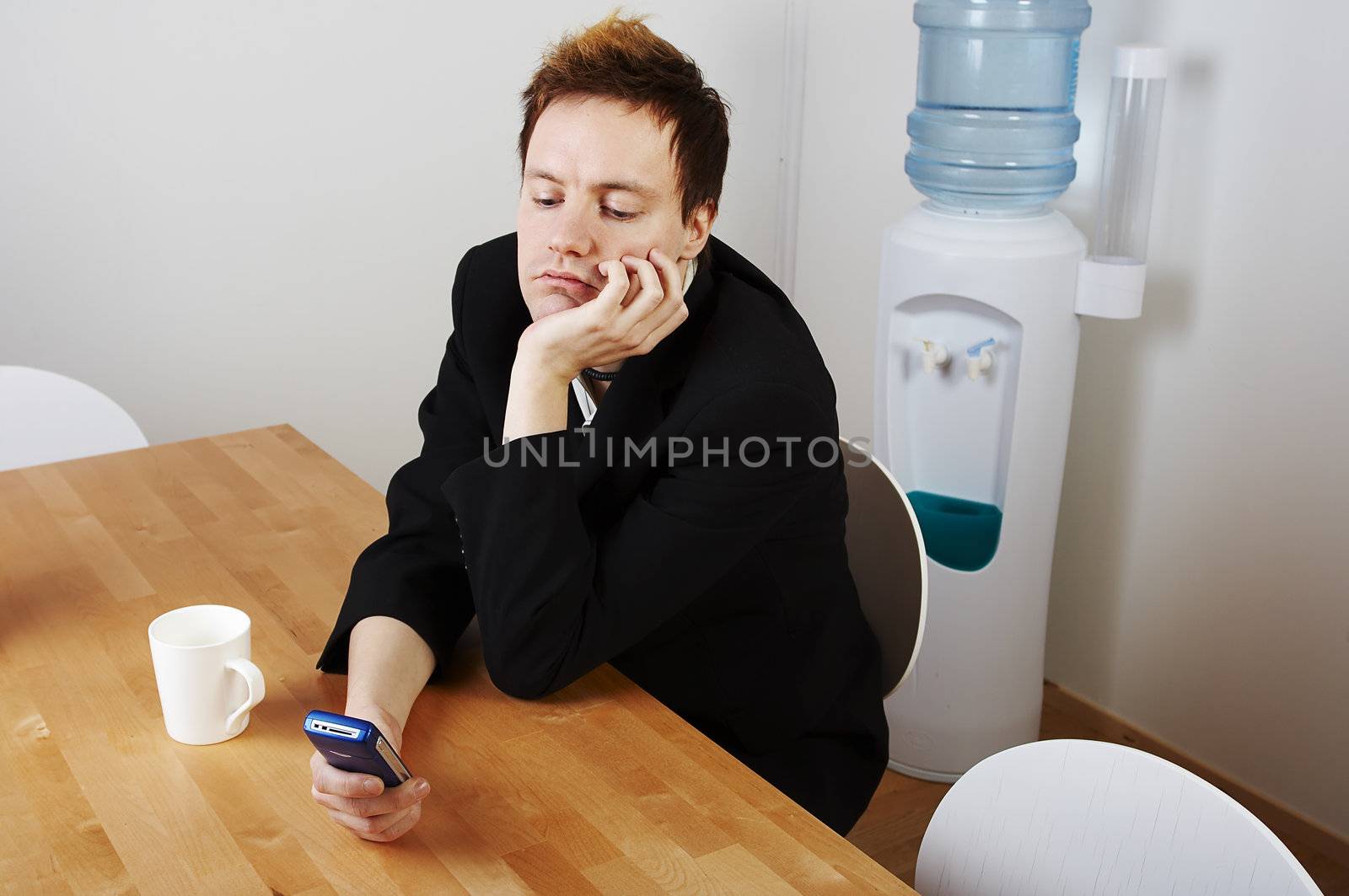 Bored salesman using his mobile phone