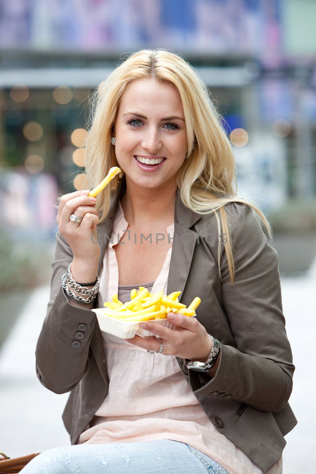 Pretty young girl eating some french fries with mayonaise