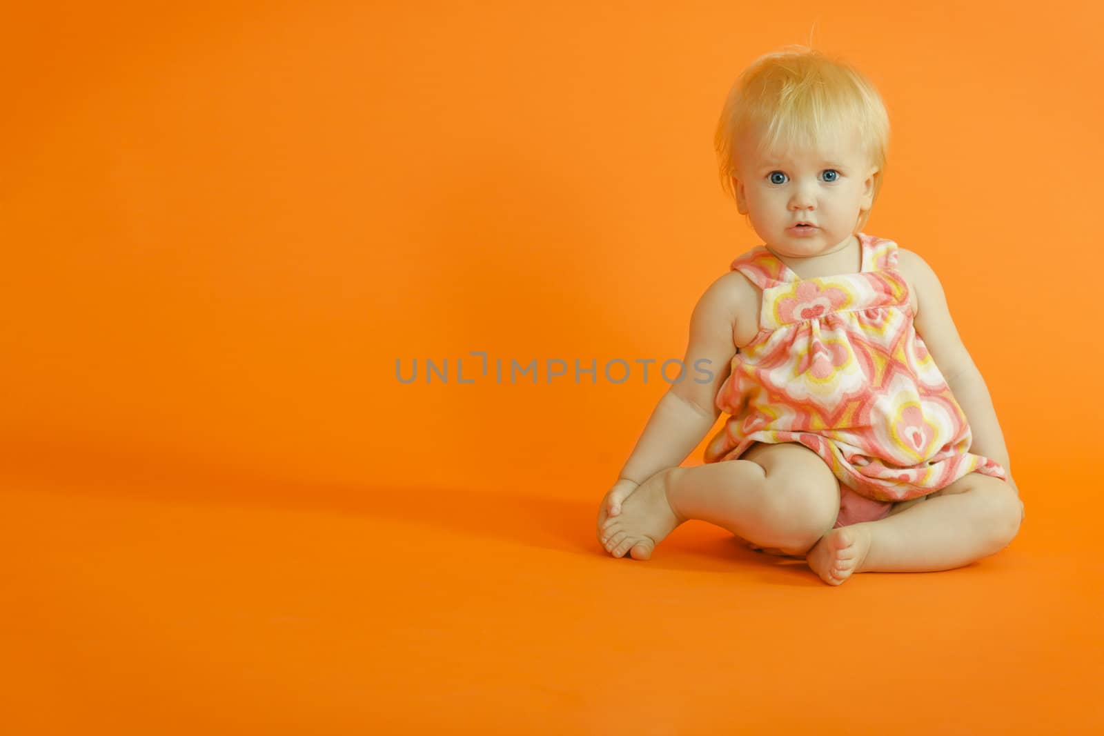 Year old girl sitting on the orange floor