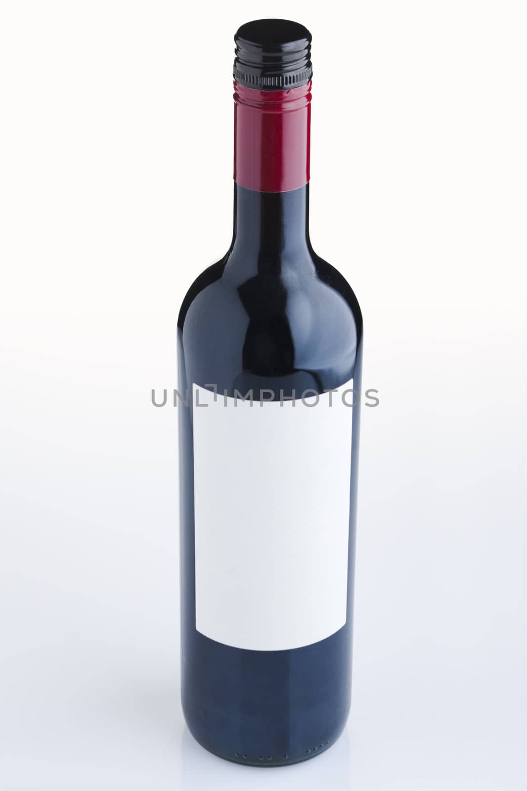 Red wine bottle with empty label over white background