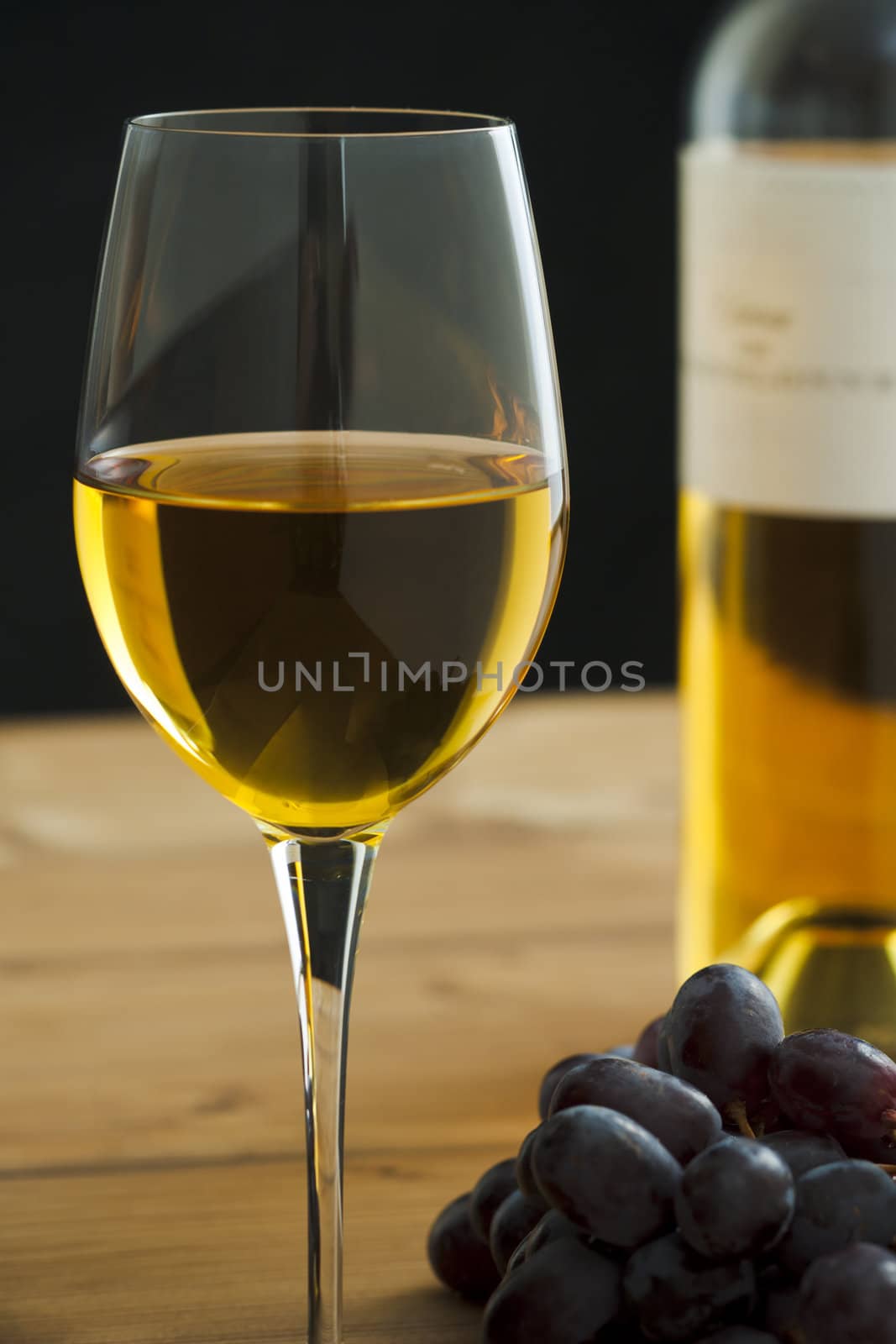 Wine glass with bottle and grapes on the table