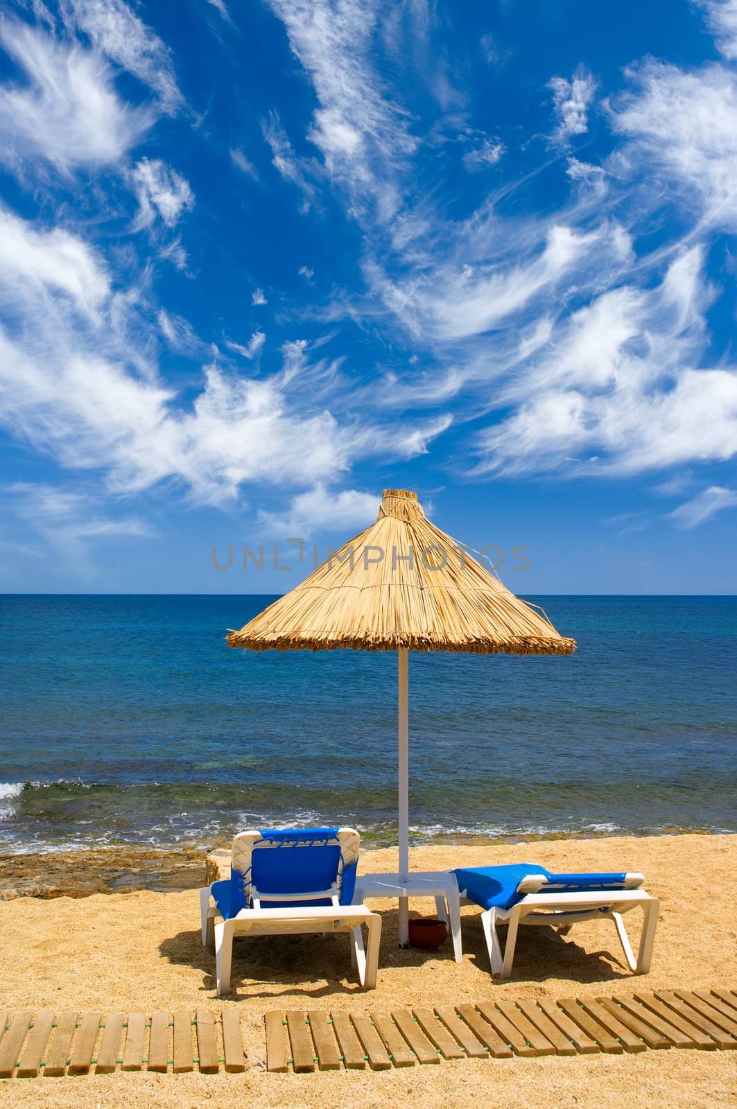 couch and sunshade on the seaside and sky with clouds