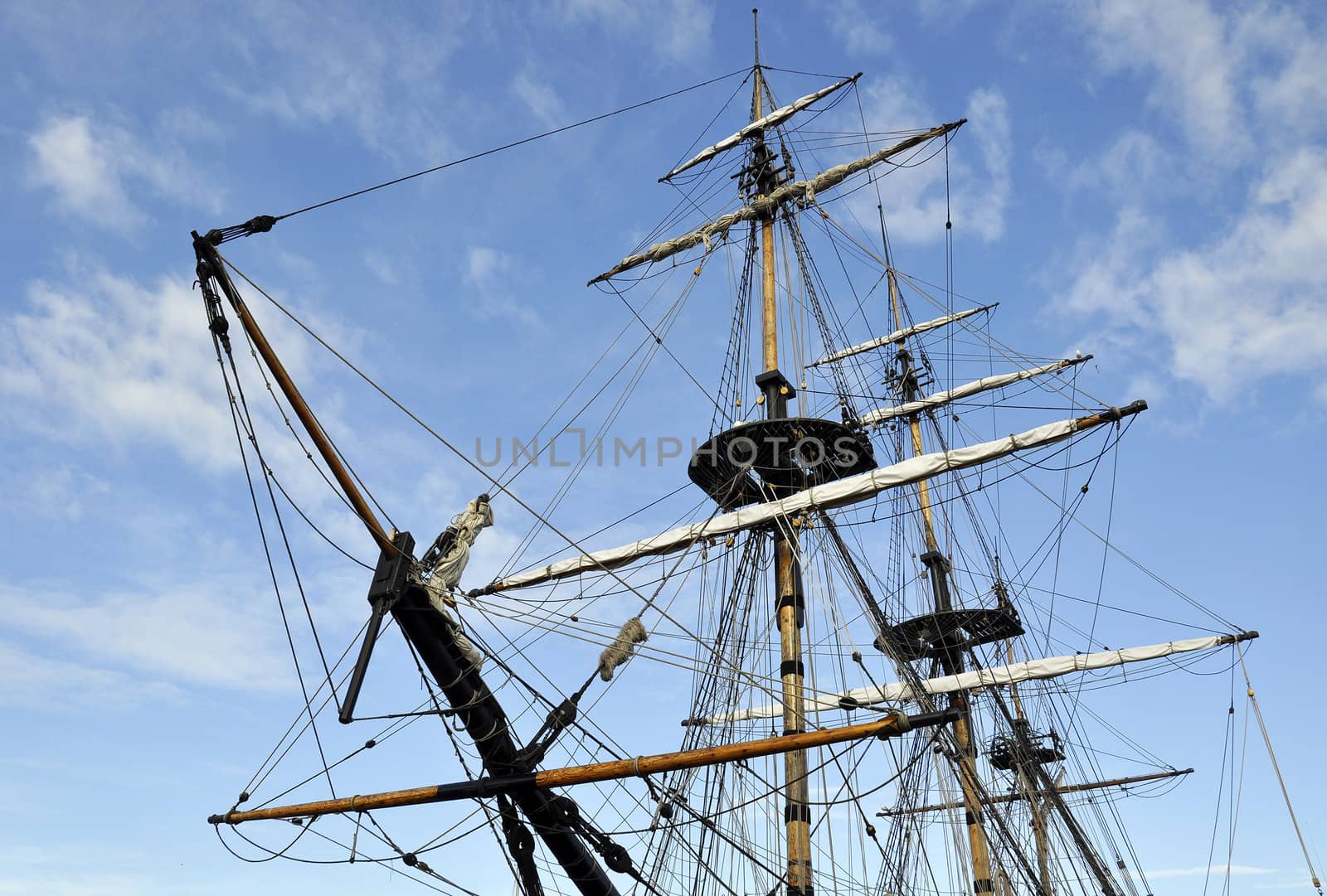 Landscape view of tall ship rigging against blue cloudy sky