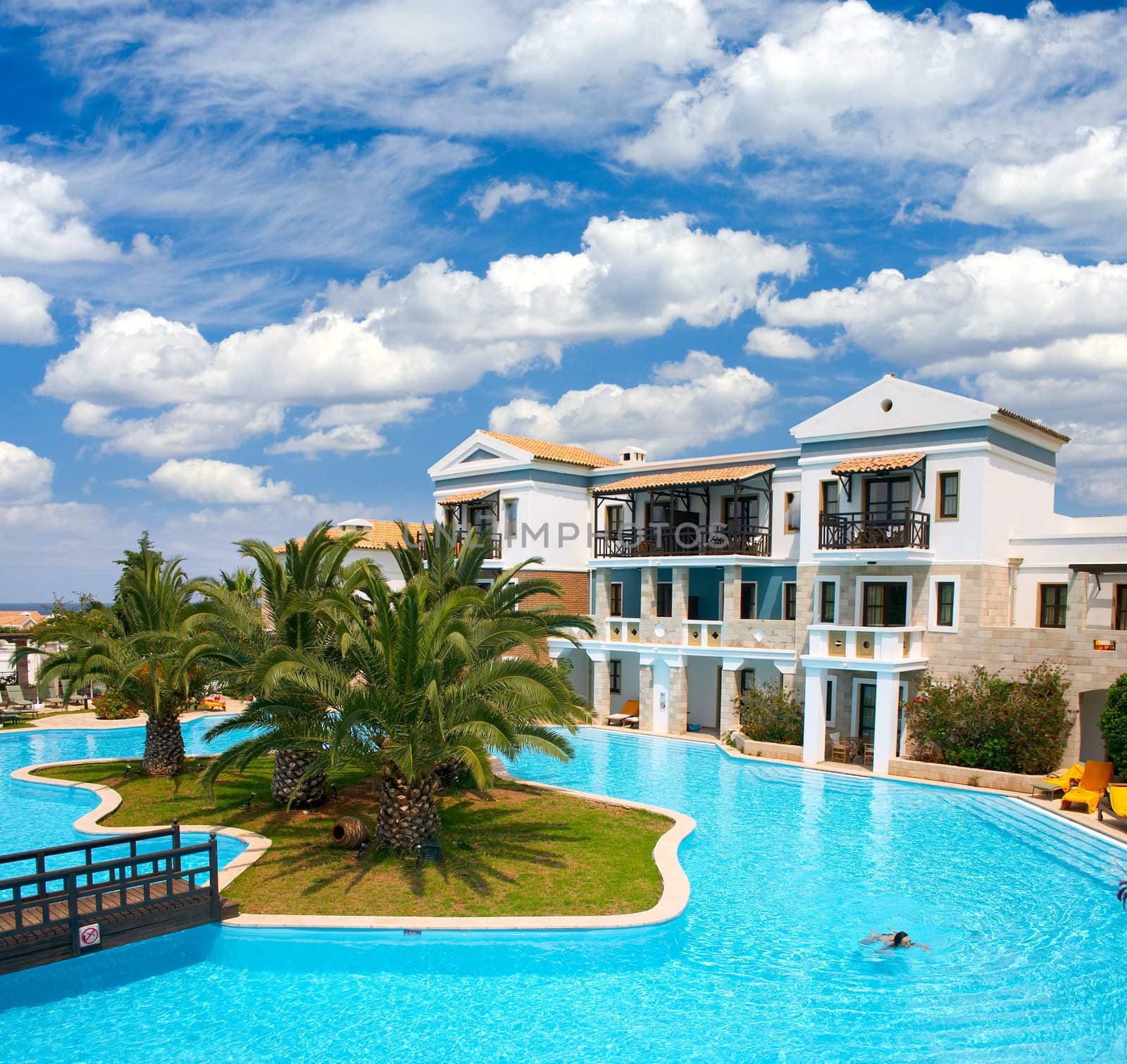 Tropical resort with palm trees and girl in swimming pool 