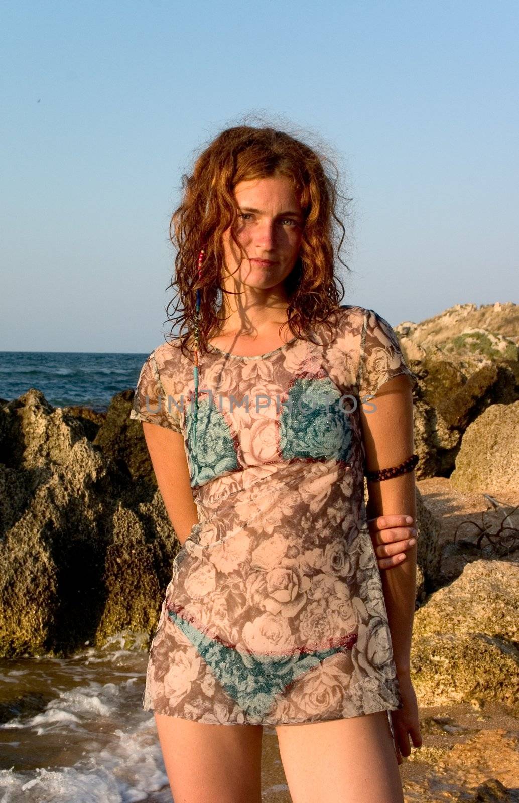 Girl in transparent dress and blue bikini at seaside