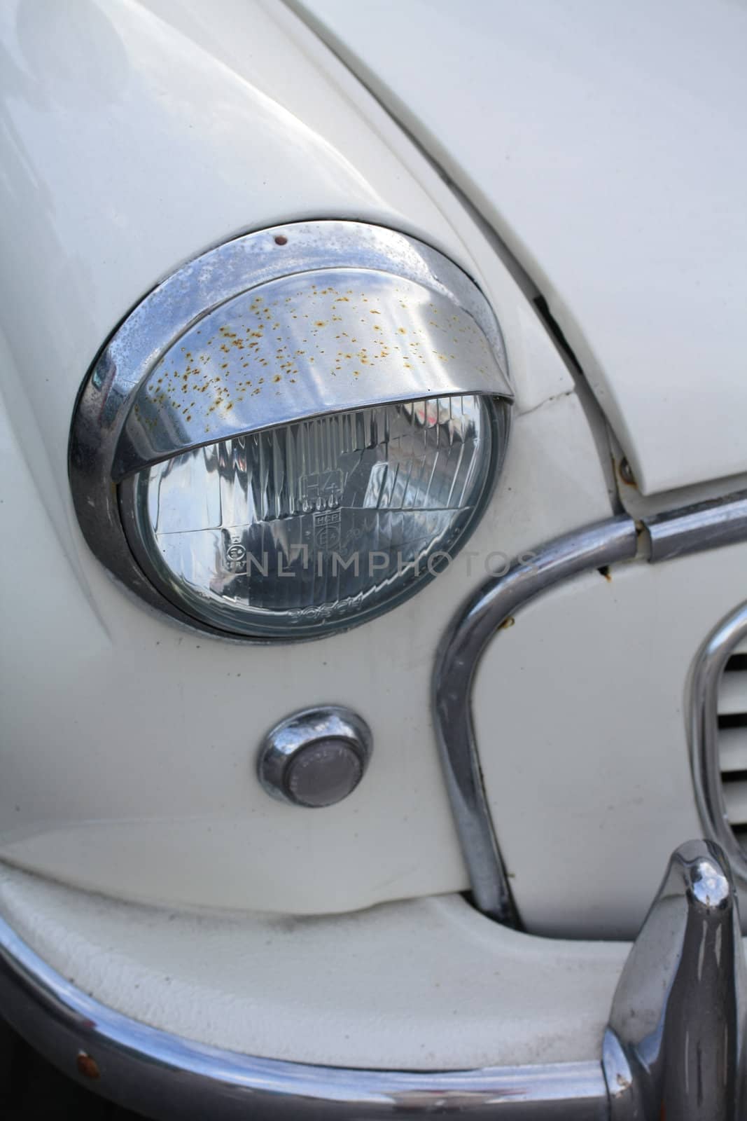 A headlight of a vintage car, made in England