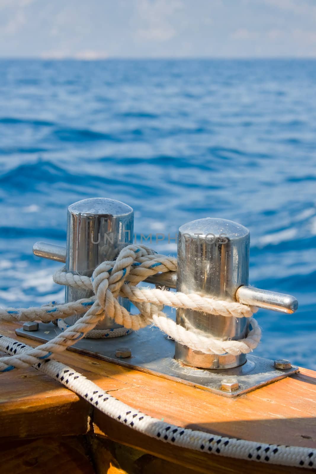 Knot on a bollard of boat. Blue sea in a background.