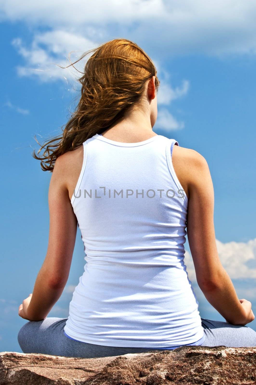 Portrait of young teenage girl practicing yoga outside