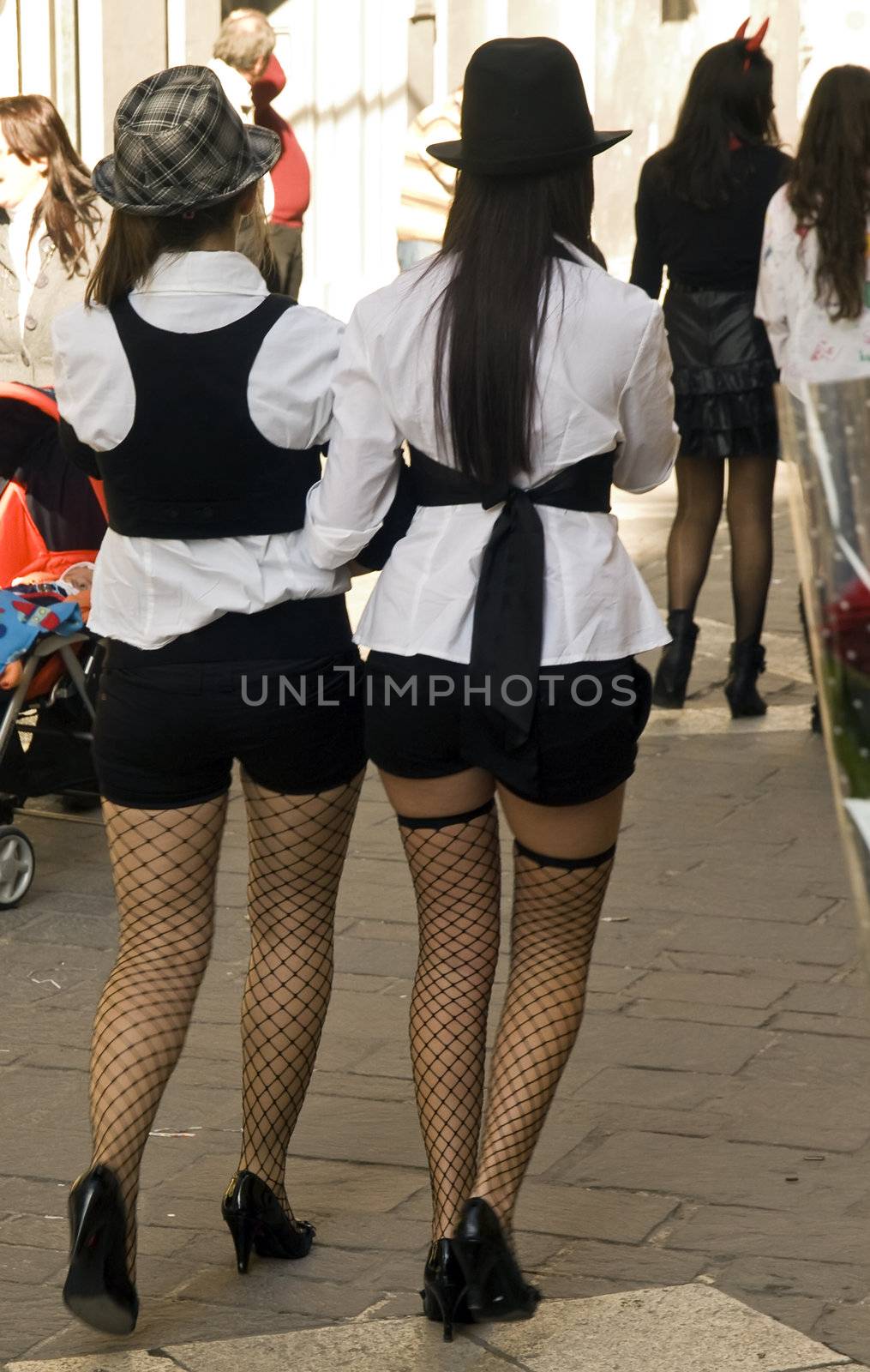 Two women walking in the street wearing sexy and provocative clothing