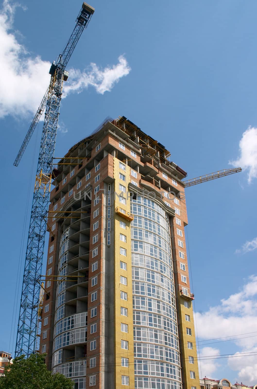 building under construction and hoisting crane
