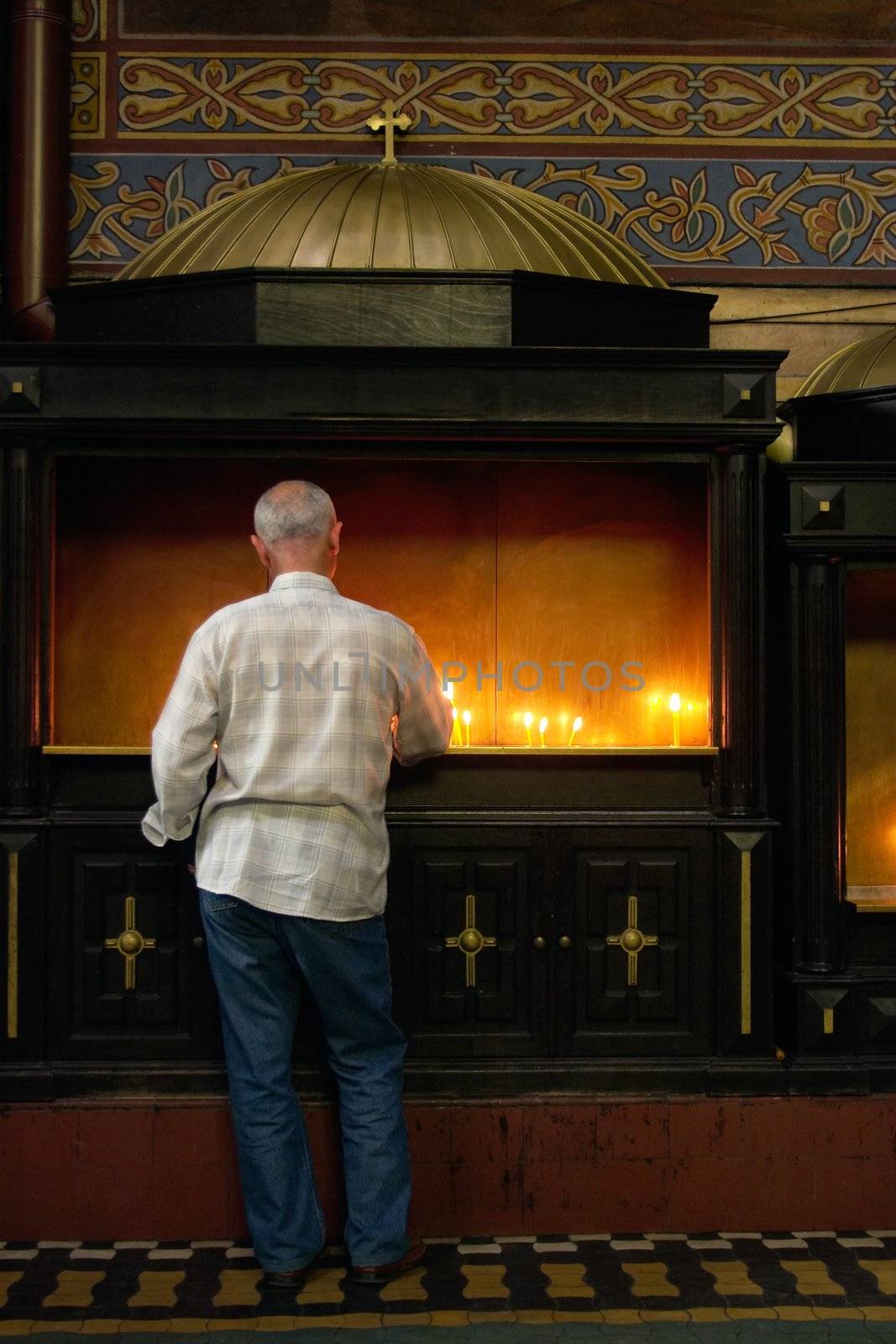 man with burning candle in catholic churche