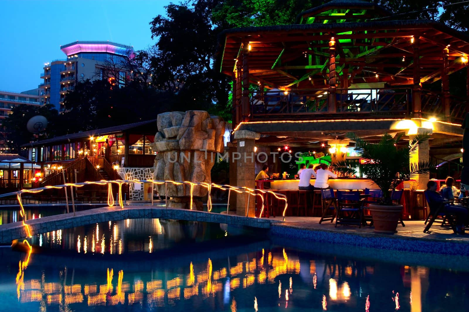 Night time photo of a swimming pool and cafe in resort.