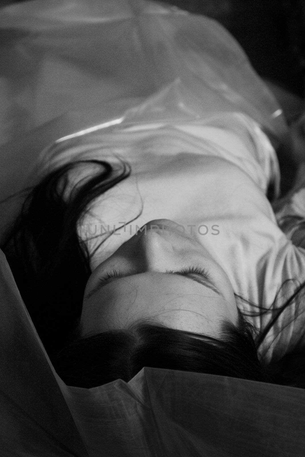 The dead beautiful girl lays in a cellophane bag
