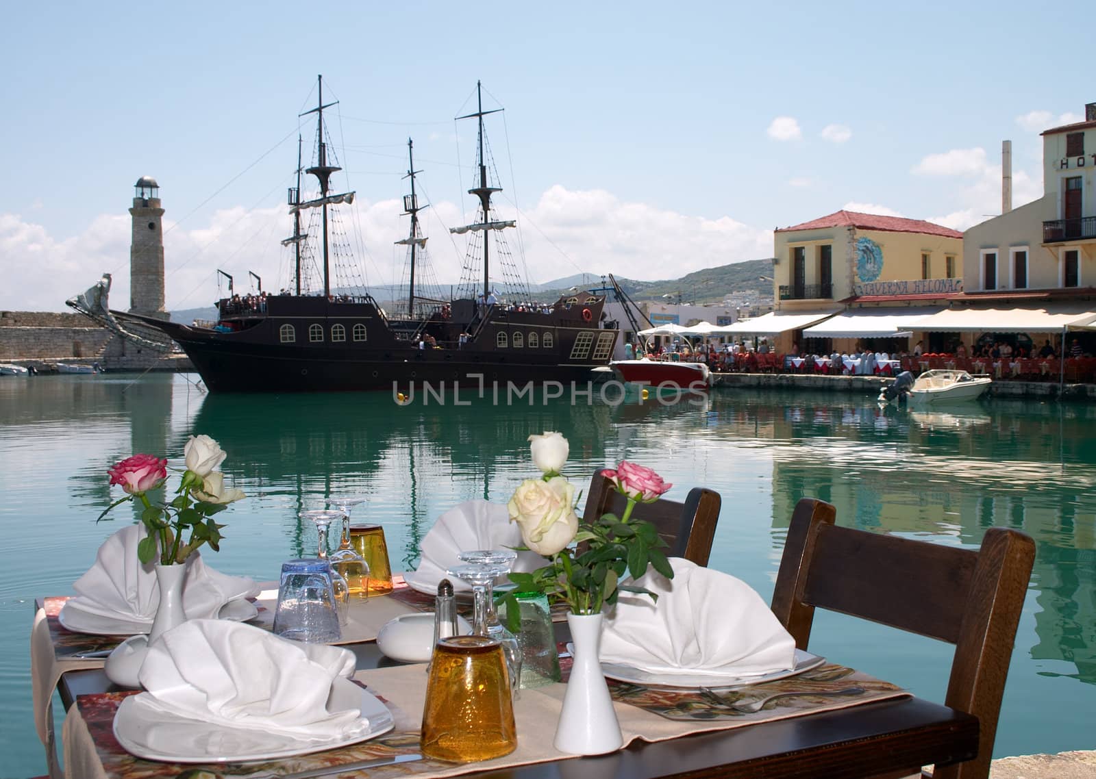 layed table in cafe on the seaside, near of sailing ship