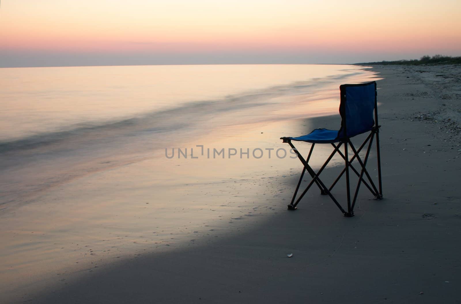 Loneliness camp-chair on the sea shore at the time of sunshine