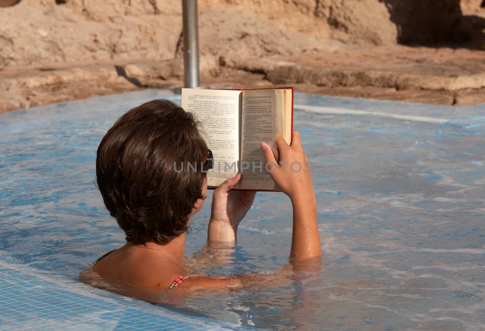 Woman reading a book in spa pool