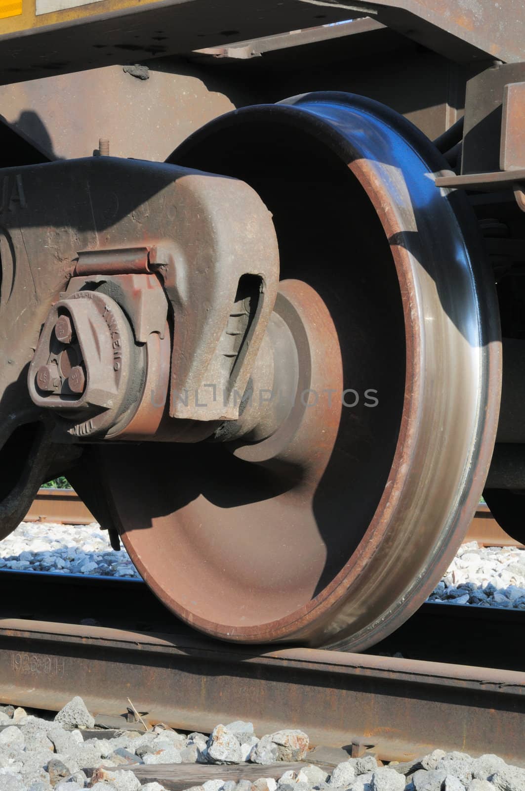 rusty and polished freight train wheel on railroad track