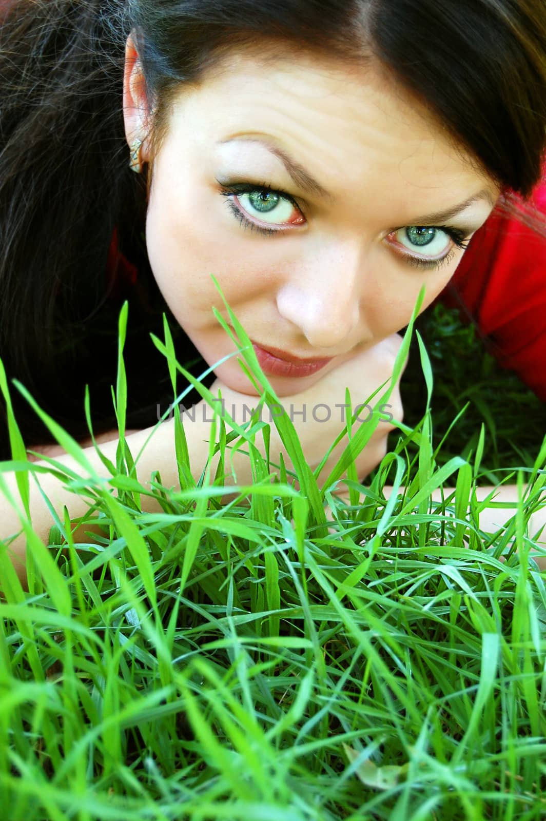 beautiful girl lying in green grass